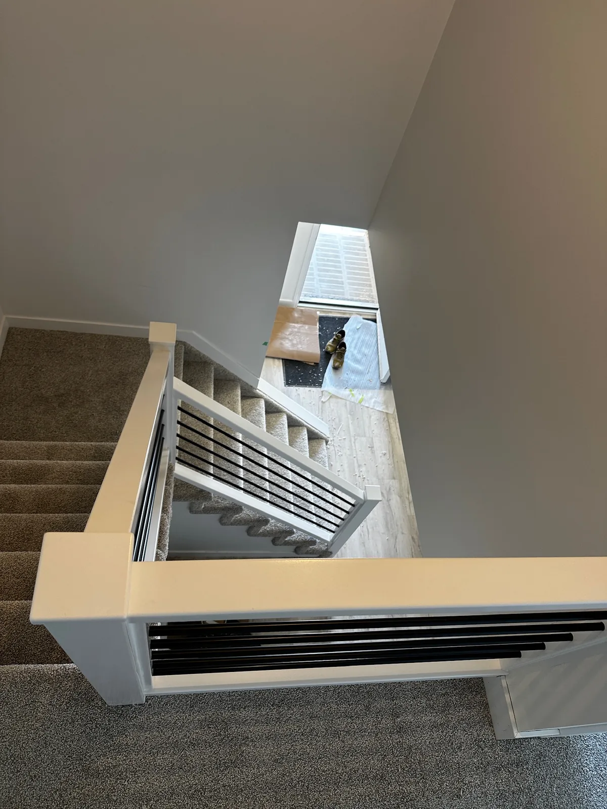 White painted railing with flat black horizontal bars on a carpeted landing